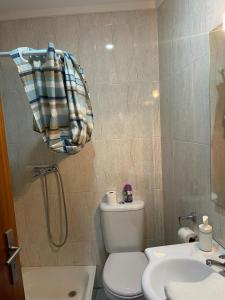a bathroom with a toilet and a sink and a shower at flat4u in Paredes +2 photos