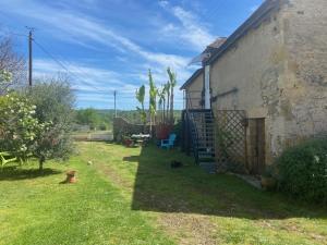 a yard of a house with a dog sitting in the grass at La Requeyrie in Montignac