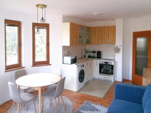 a living room with a table and a kitchen at Sapphire Mountain 2 in Bansko