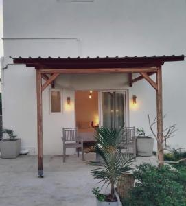 un patio con pérgola de madera y una silla en Residence de la Montagne, en Quatre Vents