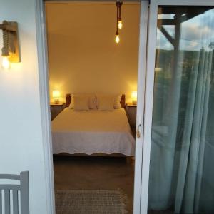 1 dormitorio con 1 cama junto a una puerta corredera de cristal en Residence de la Montagne, en Quatre Vents