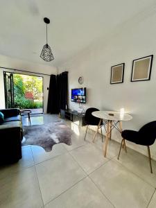 - un salon avec un canapé et une table dans l'établissement Apartment close to Menlyn Maine, à Pretoria