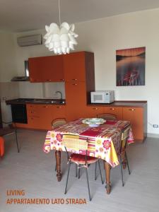 uma cozinha com uma mesa com uma toalha de mesa em Bilocali Approdo "Fronte Mare" e "Lato Strada" em Porto Cesareo