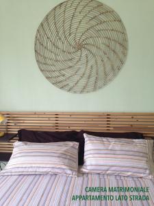 a large wreath hanging on the wall above a bed at Bilocali Approdo "Fronte Mare" e "Lato Strada" in Porto Cesareo