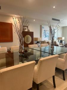 ein Esszimmer mit einem Glastisch und Stühlen in der Unterkunft Spacious Luxury 3 bedroom apartment - Southridge - Mellieha in Mellieħa