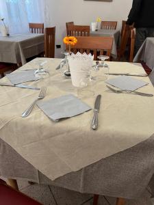 een tafel met keukengerei en servetten op een tafel bij Due Gemelle in Rimini