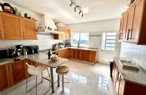 a kitchen with wooden cabinets and a table with chairs at Fantastic villa with panoramic coastal & sea views in Estói