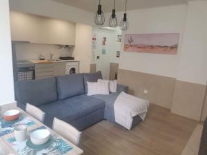 a living room with a blue couch and a table at Enjoy Lisboa 2! - Near Metro in Amadora