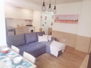 sala de estar con sofá azul y mesa en Enjoy Lisboa 2! - Near Metro en Amadora