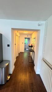 un corridoio con pareti bianche e pavimenti in legno di Luxury Home with Gym/Outdoor play area - 40 mins from Luton/Stansted a Knebworth