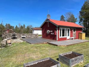een rood huis met een terras in een tuin bij Hörlösa in Löttorp