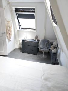 een slaapkamer met een bed, een bureau en een raam bij Volledige bovenwoning binnenstad in Leeuwarden