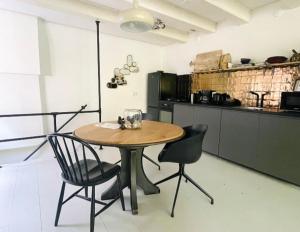 een keuken met een houten tafel en 2 stoelen bij Volledige bovenwoning binnenstad in Leeuwarden