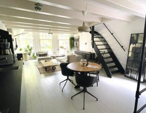 een woonkamer met een tafel en een wenteltrap bij Volledige bovenwoning binnenstad in Leeuwarden