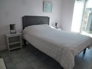 een slaapkamer met een groot bed en een wit dekbed bij Maison Ustou46 in Cahors