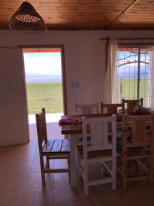 comedor con mesa, sillas y ventana en Casa Portal del Lago en El Mollar