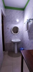 baño con lavabo y espejo en la pared en Ngalawa Bush Route Hostel, en Dar es Salaam