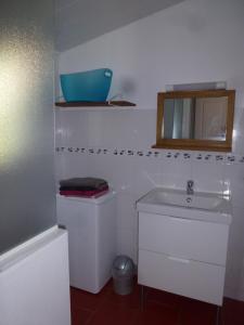 een witte badkamer met een wastafel en een spiegel bij Maison Ustou46 in Cahors