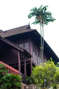 a house with a palm tree in front of it at Carpe Diem Orchard Home in Rawang
