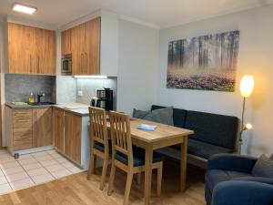 eine Küche und ein Wohnzimmer mit einem Tisch und Stühlen in der Unterkunft Appartementhaus Inntalblick in Bad Füssing