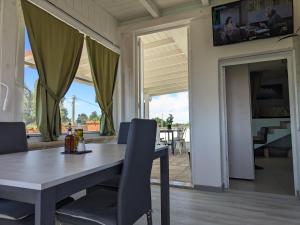 ein Esszimmer mit einem Tisch und Stühlen sowie eine Terrasse in der Unterkunft Attico Nel Verde - Bonsignore in Tricase