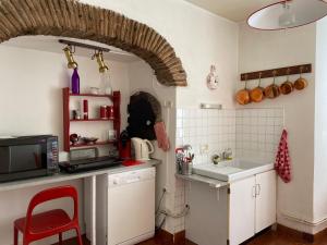 a kitchen with a red chair and a microwave at CHEZ VOUS... à La CHANOINERIE in Brioude