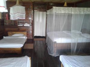 1 dormitorio con 2 camas y dosel en Ngalawa Bush Route Hostel, en Dar es Salaam