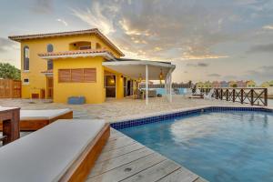 a villa with a swimming pool in front of a house at Casa Chillville in Water Villas Bonaire in Kralendijk