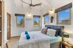 Schlafzimmer mit einem Bett und einem Deckenventilator in der Unterkunft Casa Chillville in Water Villas Bonaire in Kralendijk