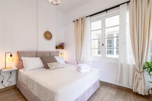 Habitación blanca con cama y ventana en Monastiraki Luxury Loft en Atenas