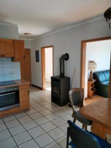 a kitchen with a stove and a table and chairs at Zum Gänseglück in Reut