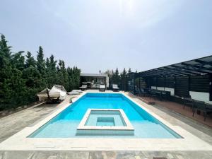 a swimming pool in the middle of a house at Luxe Two Bedroom Villa by Olivujoj in Anavyssos