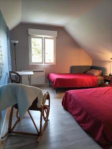 Habitación en el ático con 2 camas y mesa en Maison de Laurence - La Chaumiére de Mauvrain en La Celle-sur-Nièvre