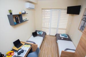 a small room with two beds and a table at Turnovo Smart Studio - Cozy Work & Relax in Veliko Tŭrnovo