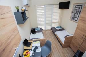 a small room with a bed and a desk with a laptop at Turnovo Smart Studio - Cozy Work & Relax in Veliko Tŭrnovo