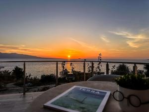 einen Tisch mit Blick auf das Meer bei Sonnenuntergang in der Unterkunft Sunny Coast Apartments in Sarandë