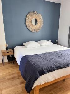 1 dormitorio con 1 cama con pared azul y espejo en Le Rabelais, superbe appartement en duplex, proche forteresse et monument historique, en Chinon