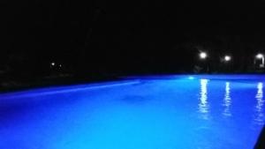 una piscina con luces azules por la noche en The Nyerere Selous Ngalawa Tented Camp en Kwangwazi