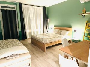 a bedroom with two beds and a table and a desk at Mini Alloggi Alle Terme in Abano Terme