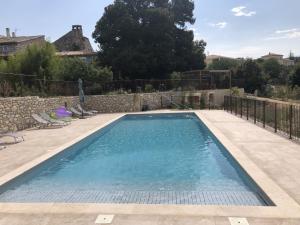 a swimming pool with blue water in a yard at Chambre d'hôtes Bambou- A l'Ombre des Tilleuls in Lagorce