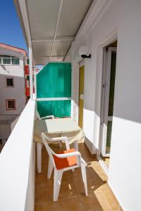 a small balcony with a table and a chair at Apartments AriaSana in Dobra Voda