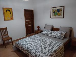a bedroom with a bed and a chair at La Georgeanne in Mbour