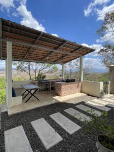 een patio met een picknicktafel en een houten pergola bij Breathtaking Mountain Views in La Union, El Salvador in La Unión
