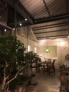 a dining room with a table and chairs and plants at 97 Yaowarat - Phuket Old Town in Phuket