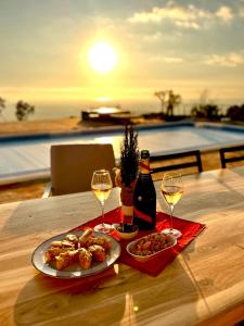 einen Tisch mit einem Teller Essen und zwei Gläsern Wein in der Unterkunft Fantastic villa with panoramic coastal & sea views in Estói