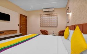 - une chambre avec un grand lit et une télévision dans l'établissement Hotel Abhilasha inn, à Pachmarhī