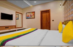 1 dormitorio con 1 cama grande y TV en Hotel Abhilasha inn, en Pachmarhī