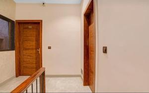 un couloir avec une porte en bois et un escalier dans l'établissement Hotel Abhilasha inn, à Pachmarhī