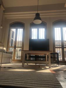 a living room with a flat screen tv in front of windows at 97 Yaowarat - Phuket Old Town in Phuket +56 photos