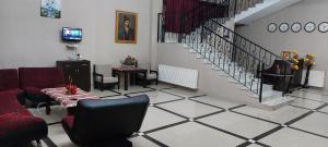 a living room with a staircase and red chairs at Hotel Grand in Nizhnyaya Alekseyevka